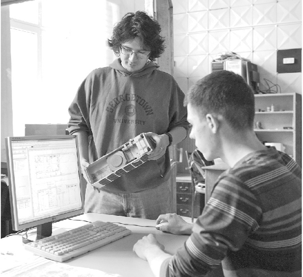 Инженер виртуального конструкторского бюро ТПУ Андрей Коломейцев держит в руках 3D-модель мини-спутника