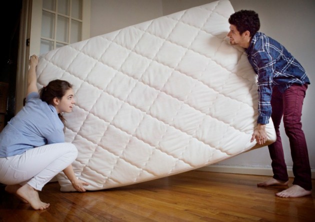 Couple Moving Mattress Into Bedroom